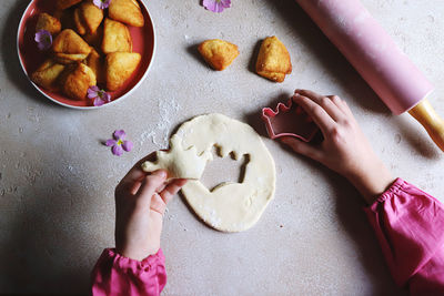 Cropped hand of person preparing food on table