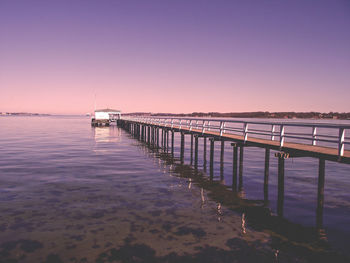 Pier over sea against sky during sunset