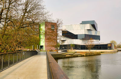 Canal amidst buildings against clear sky