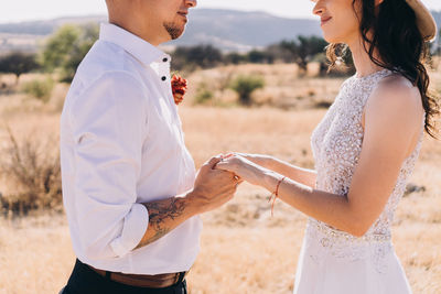 Midsection of couple holding hands