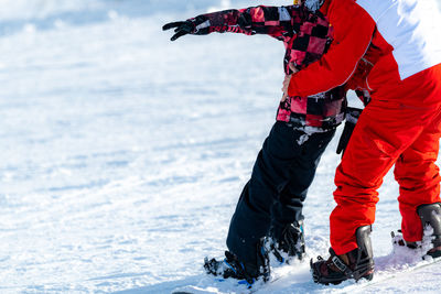 Snowboard school. boy with instructor learning snowboarding.