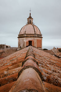 Roof of an ancient church in italy against cloudy sky