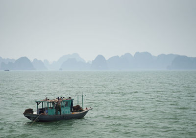 Boat sailing in sea against clear sky