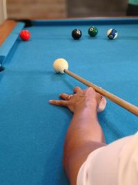 Cropped image of person playing pool ball