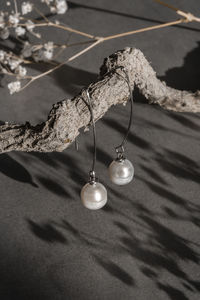 Handmade jewelry long earrings made of natural white kasumi pearls and silver on concrete background 