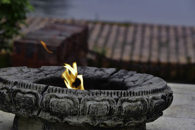 Close-up of burning candles on wood at temple