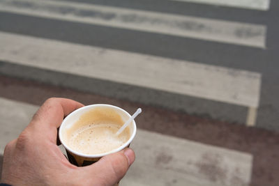 High angle view of hand holding coffee cup