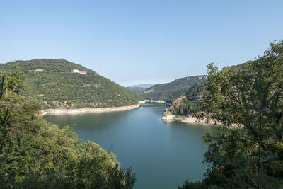 Scenic view of river amidst trees against clear sky