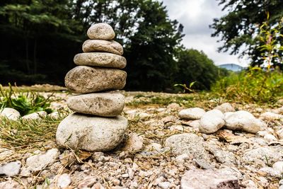 Stack of stones on rock against sky