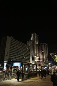 Woman in illuminated city against sky at night