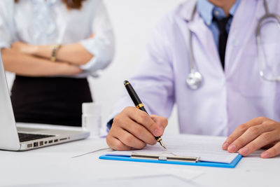 Midsection of woman using laptop on table
