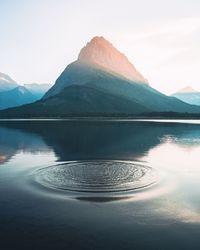 Scenic view of lake by mountains against sky