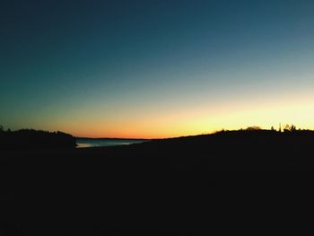 Silhouette landscape against clear sky during sunset