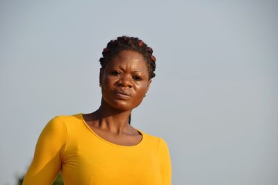 Portrait of young woman against sky