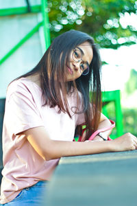 Portrait of young woman sitting outdoors