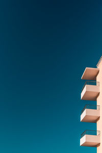 Low angle view of skyscraper against clear blue sky