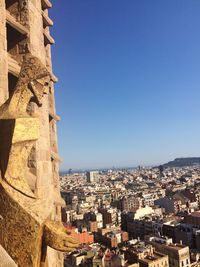 Male sculpture on sagrada familia against cityscape