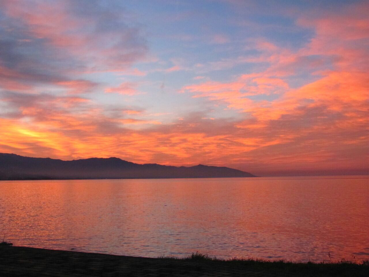 sunset, tranquil scene, scenics, water, tranquility, beauty in nature, sky, mountain, orange color, idyllic, cloud - sky, nature, sea, lake, cloud, silhouette, mountain range, reflection, dramatic sky, calm