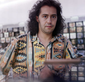 Close-up of a boy with long black hair and a colorful shirt