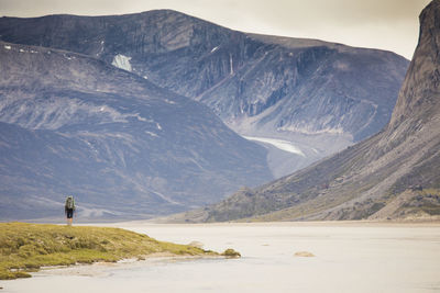 Lone backpacker hiking through akshayak pass, auyuittuq national park.