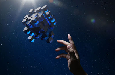 Digital composite image of man reaching towards cube shaped box in space
