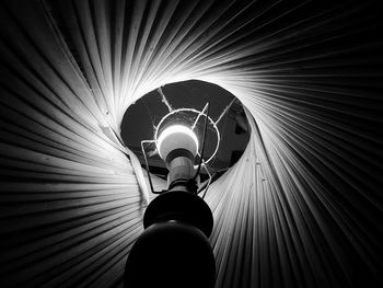 Low angle view of woman standing in illuminated tunnel