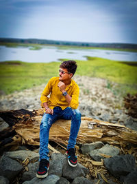 Young man sitting on rock