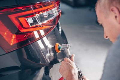 Side view of man repairing car