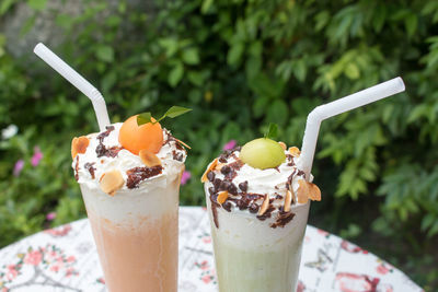 Close-up of ice cream sundae on table against plants