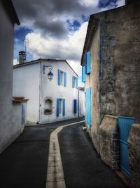 Road amidst buildings against sky