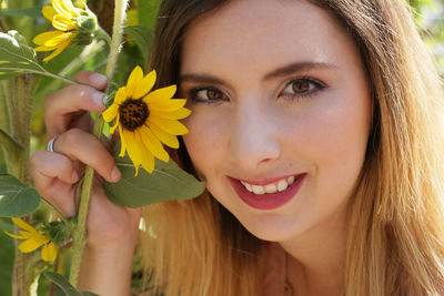 Close-up portrait of woman with yellow flowers