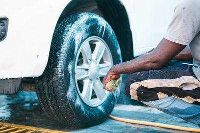 Midsection of man washing car