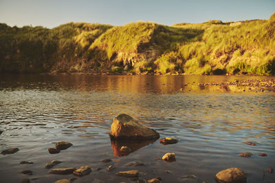 Scenic view of lake against sky at sunset