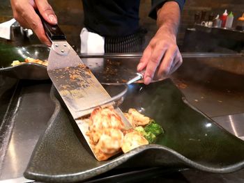 Midsection of man preparing food in restaurant