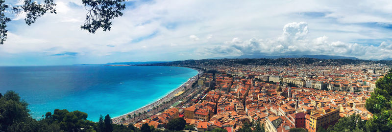 Aerial view of town by sea against sky