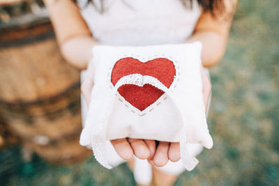 Close-up of woman holding heart shape pillow