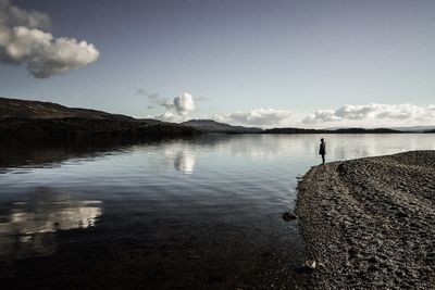 Scenic view of lake against cloudy sky