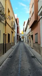 Empty road along buildings