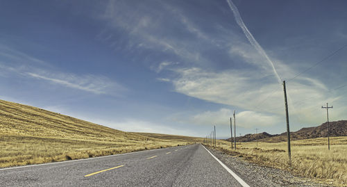 Empty road along countryside landscape