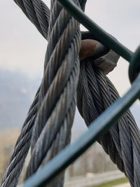 Low angle view of rope tied to wooden post
