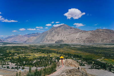 Scenic view of landscape and mountains against blue sky