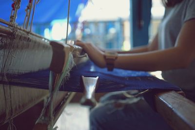 Midsection of woman holding umbrella on table