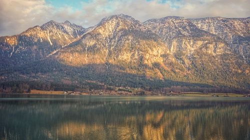 Scenic view of lake by mountains against sky