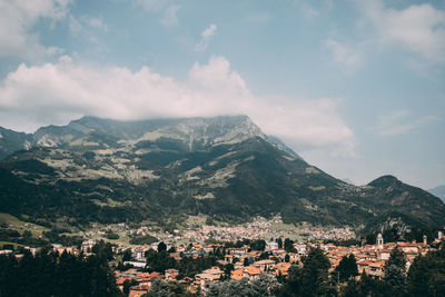 Aerial view of townscape and mountains against sky