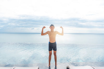 Full length of man standing on beach against sky