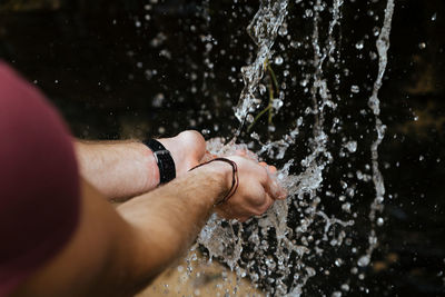Cropped hands of man splashing water