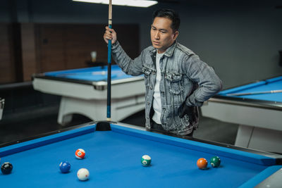 Midsection of man playing pool
