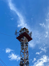 Low angle view of community tower against blue sky