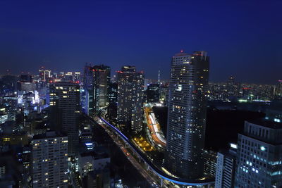 Illuminated cityscape against sky at night