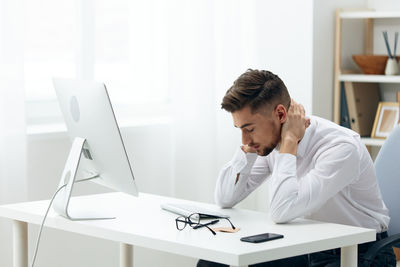 Businessman having neck ache at office